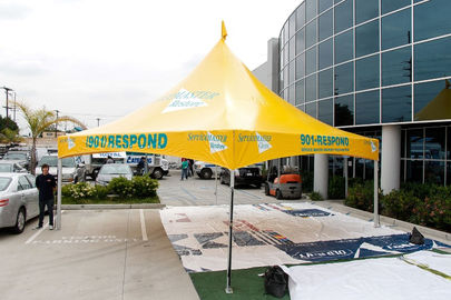 Large yellow branded event tent installed for outdoor event