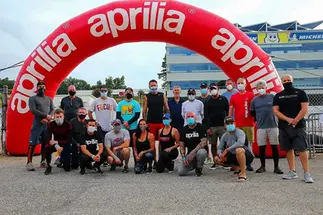 Red Aprilia inflatable arch at a racing event with participants