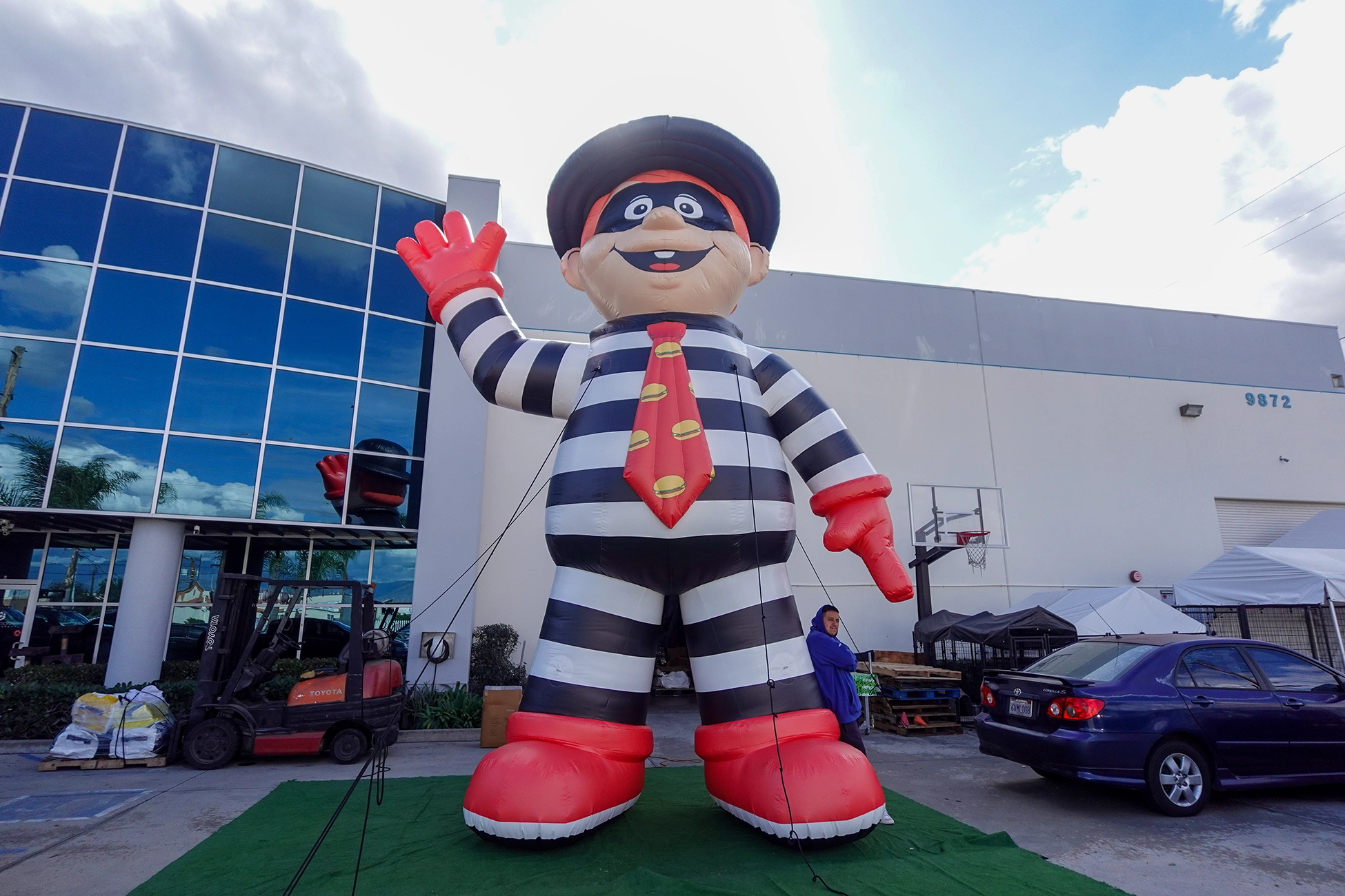 Custom inflatable character mascot with striped outfit displayed outdoors for brand promotion and event marketing.