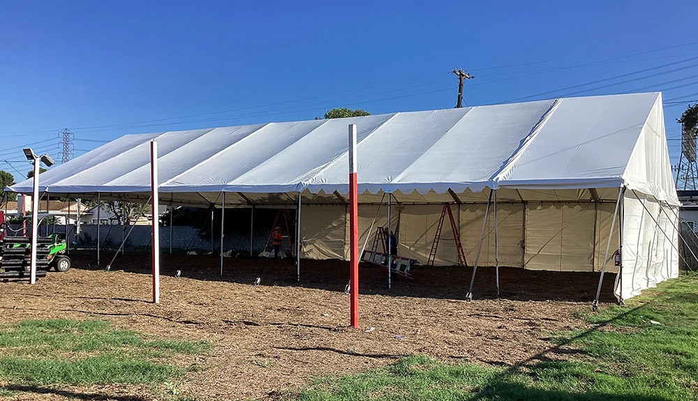 Large gable tent with high walls set up outdoors, designed for events and storage.