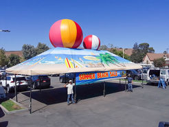 Inflatable beach balls on canopy for summer beach sale promotion.