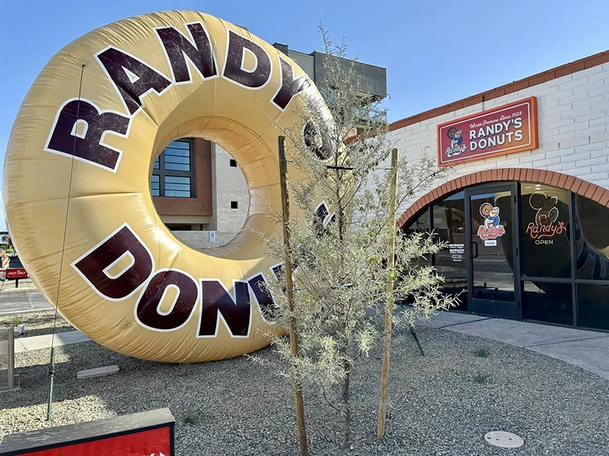 Oversized inflatable donut replica positioned outside a retail building as a branded novelty display