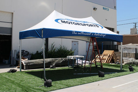 Custom 10x10 high peak tent with blue motorsports branding.