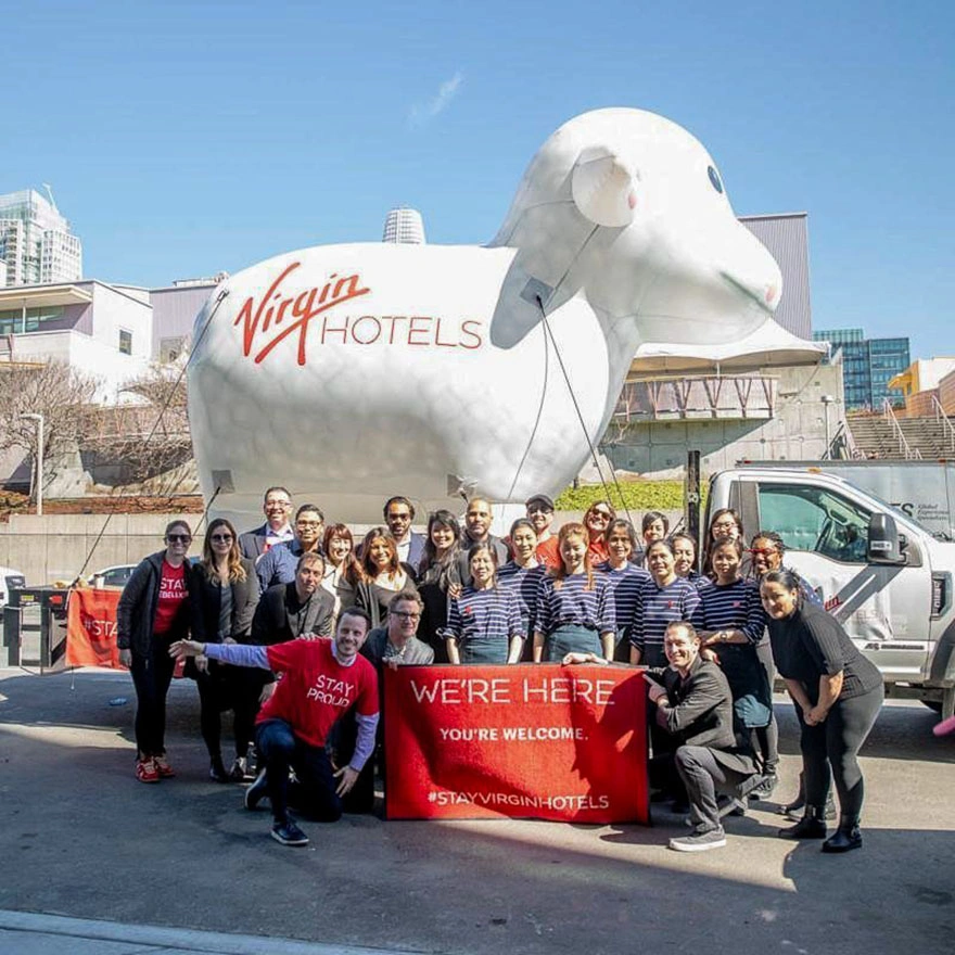 Team photo in front of a Virgin Hotels branded giant inflatable sheep named Snoozy during a hospitality activation