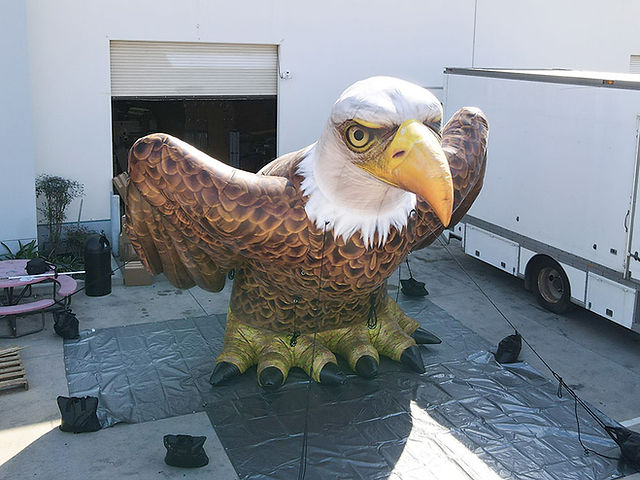 Realistic inflatable bald eagle with spread wings, detailed feathers, beak, and talons