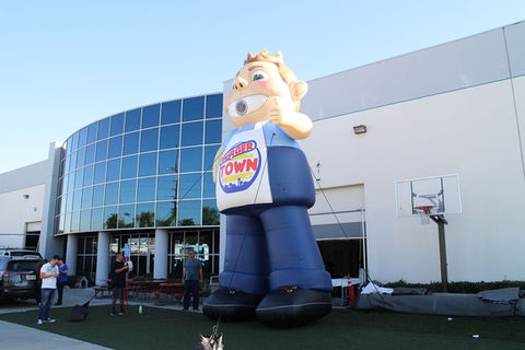 Large inflatable mascot statue featuring a character in branded attire, set up for a promotional event.