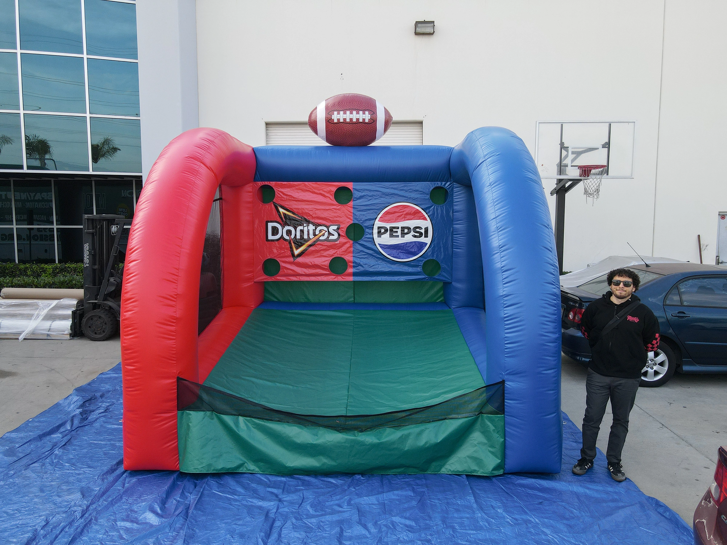 Custom inflatable football toss game featuring Doritos and Pepsi branding at a promotional event