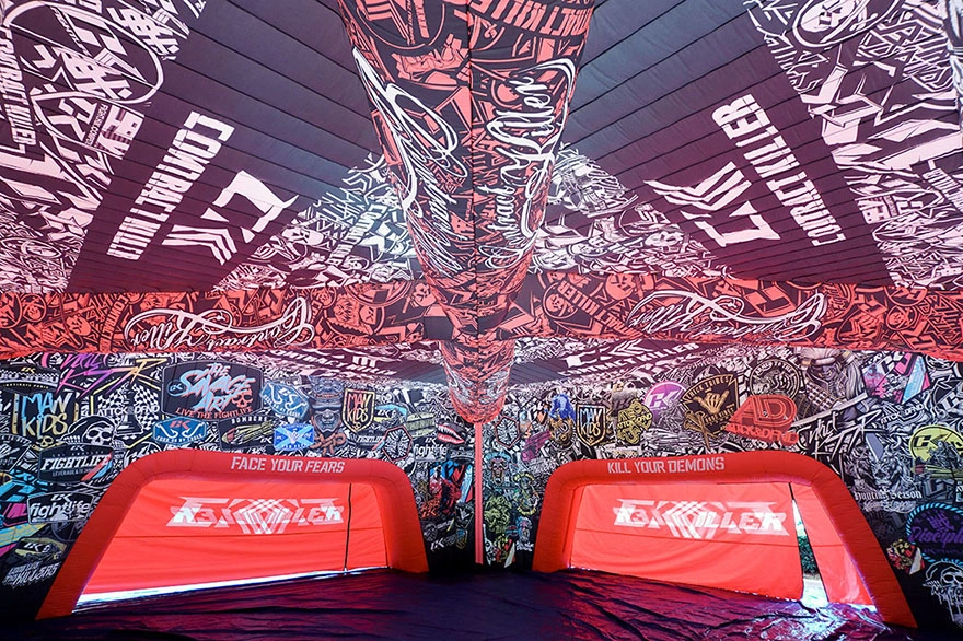Wide interior view of a large inflatable commercial tent with full printed walls and ceiling graphics, showing multiple arched openings.