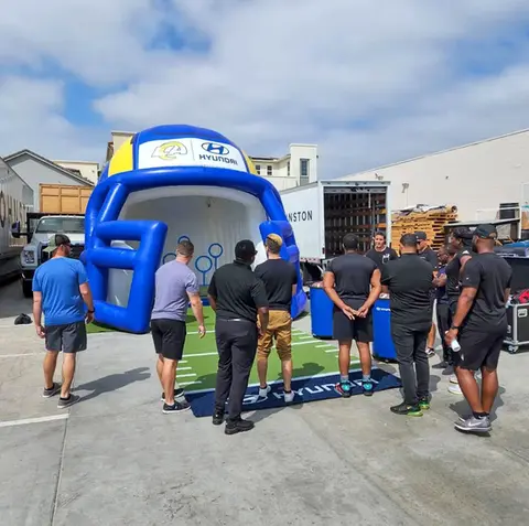 Large inflatable football helmet with Hyundai Chargers branding at an outdoor promotional event.
