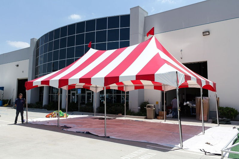 Red and white striped high-peak tent set up for outdoor activation