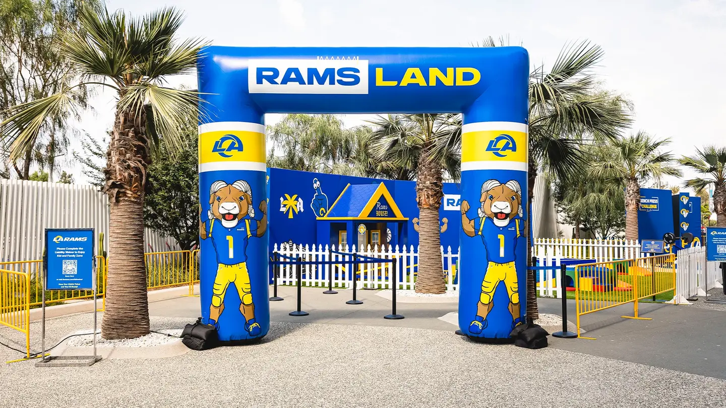 Inflatable Rams Land entrance arch set up at a sports event, decorated with team mascots and branding.