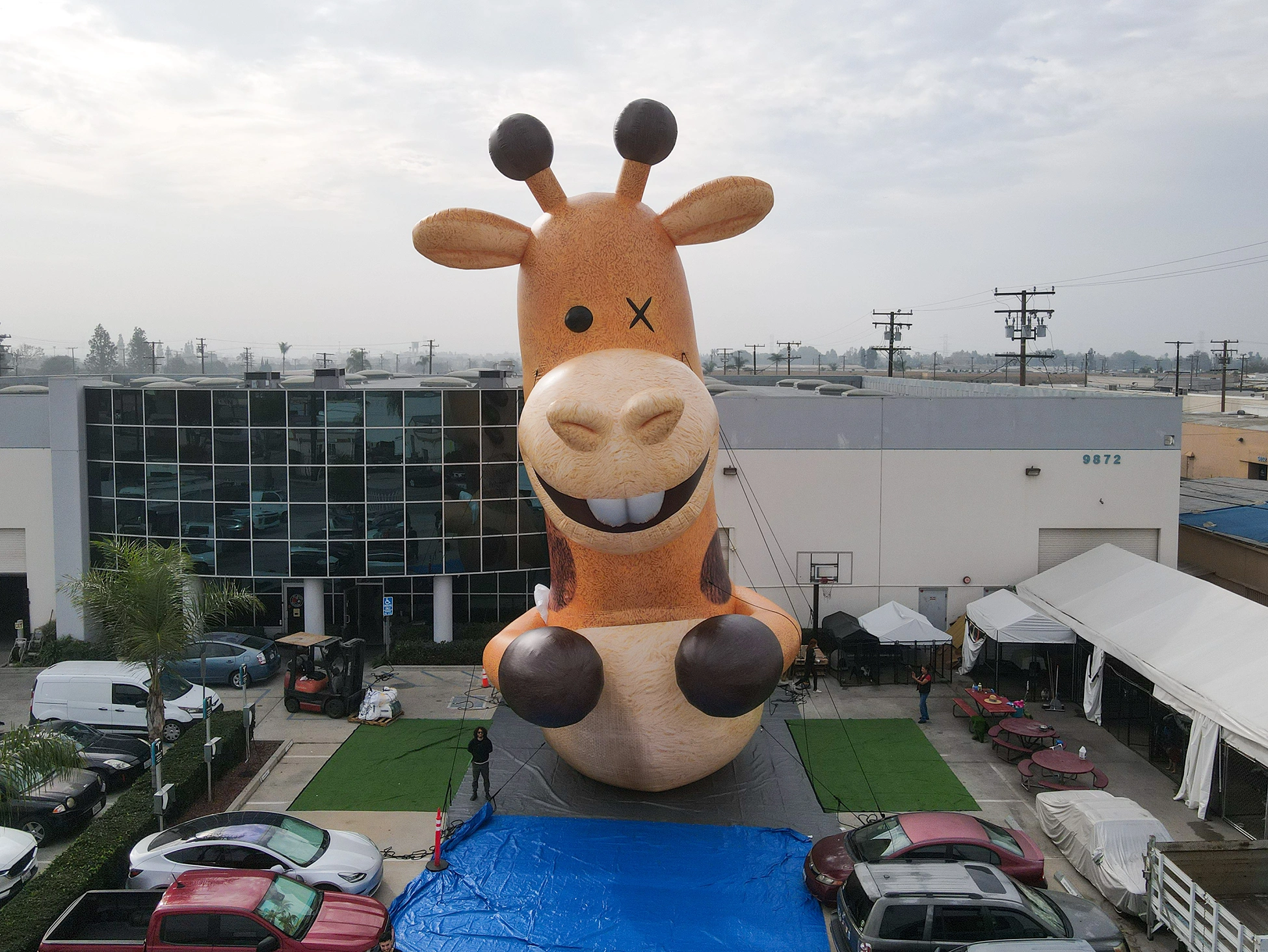 38ft custom inflatable giraffe character mascot displayed outdoors for brand promotion and event marketing.