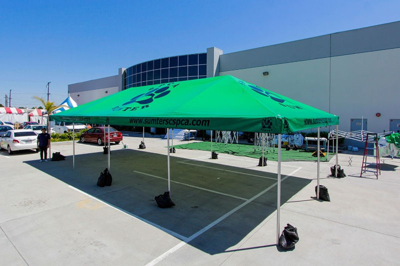 Large green SPCA canopy tent with custom graphics in parking lot