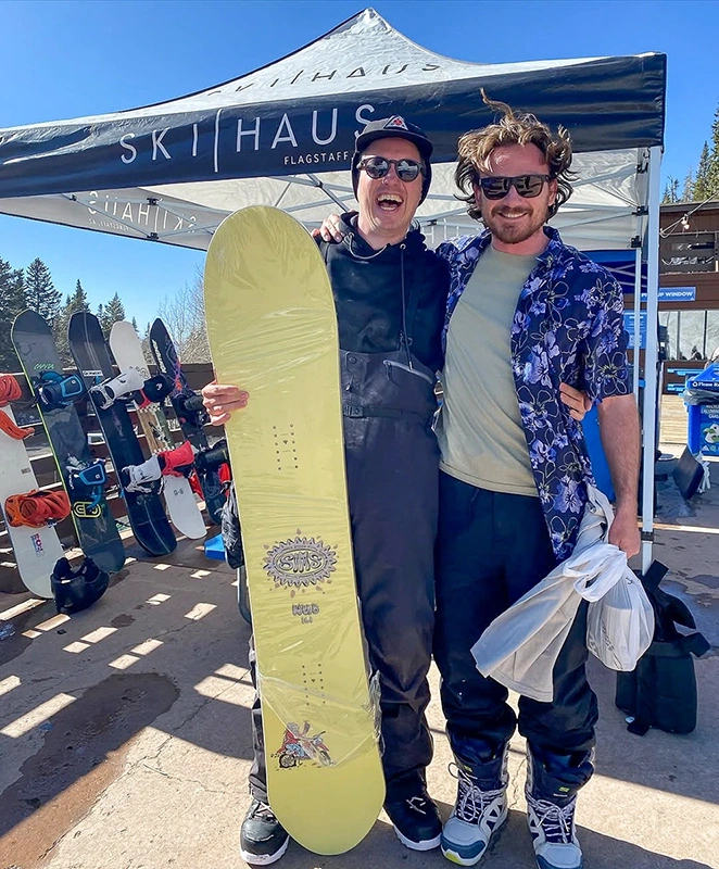 Two snowboarders posing under Ski Haus custom pop up canopy