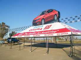 Inflatable Kia Optima on printed canopy tent for car dealership promotion.