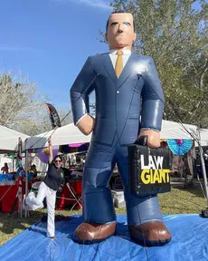 Custom giant inflatable Law Giant character display at an outdoor branded event
