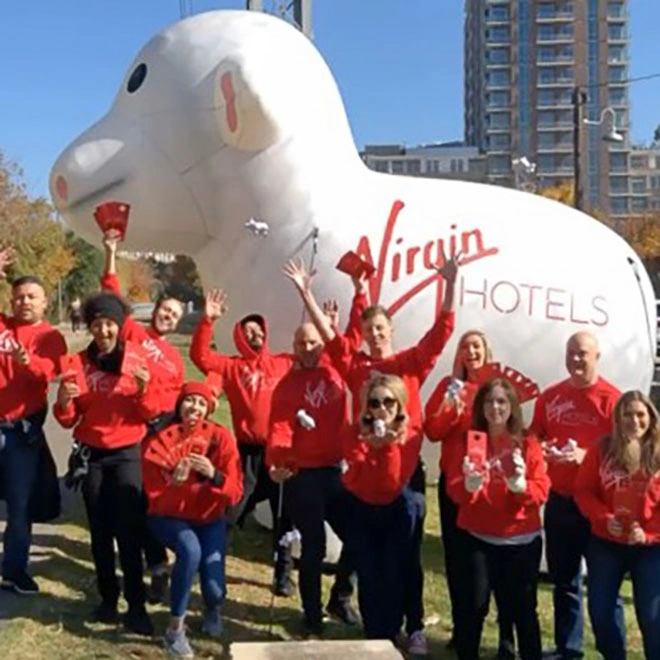 Group photo in front of a Virgin Hotels branded giant inflatable sheep display used for a promotional event setup
