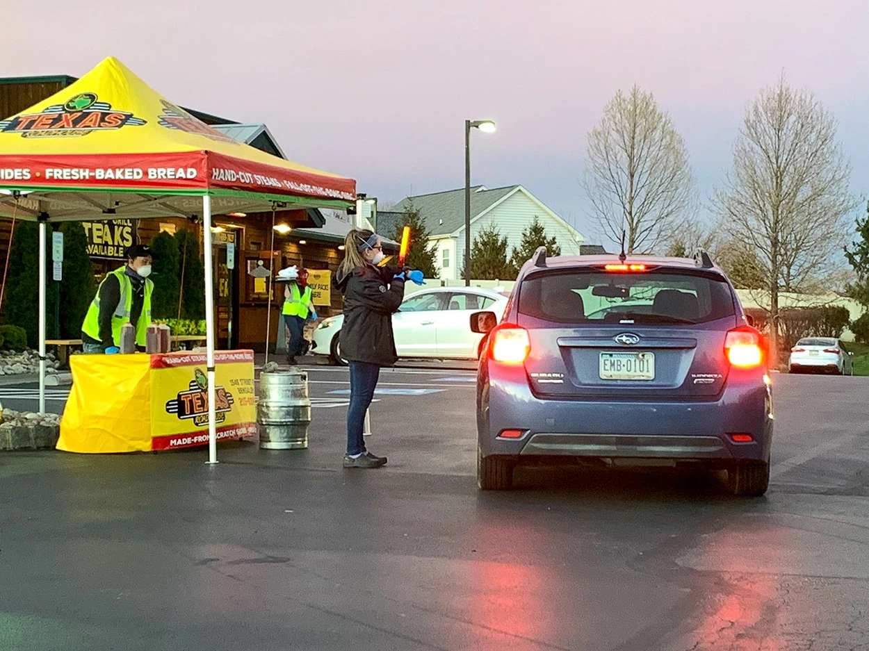 Restaurant canopies set up for pickup orders and drive-thru service outside eateries.