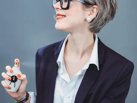 Elegant woman holding a perfume bottle, representing the boutique fragrance experience at La Parfumerie USA in Crabtree Valley Mall Raleigh.