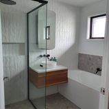 Main bathroom of a house in Brisbane after Milu Interiors re-designed the space, including new tiles, bathtub, cabinetry, and hardware