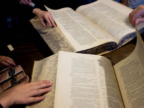 children's hands turning the pages of two old dictionaries