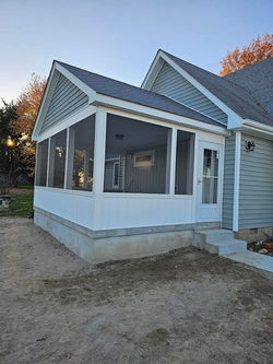 Completed screened-in porch with concrete base and white trim