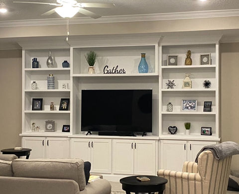 Elegant white entertainment center with decoratively arranged shelves, and a central television space