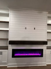 Modern custom cabinetry with electric fireplace and open stained shelves