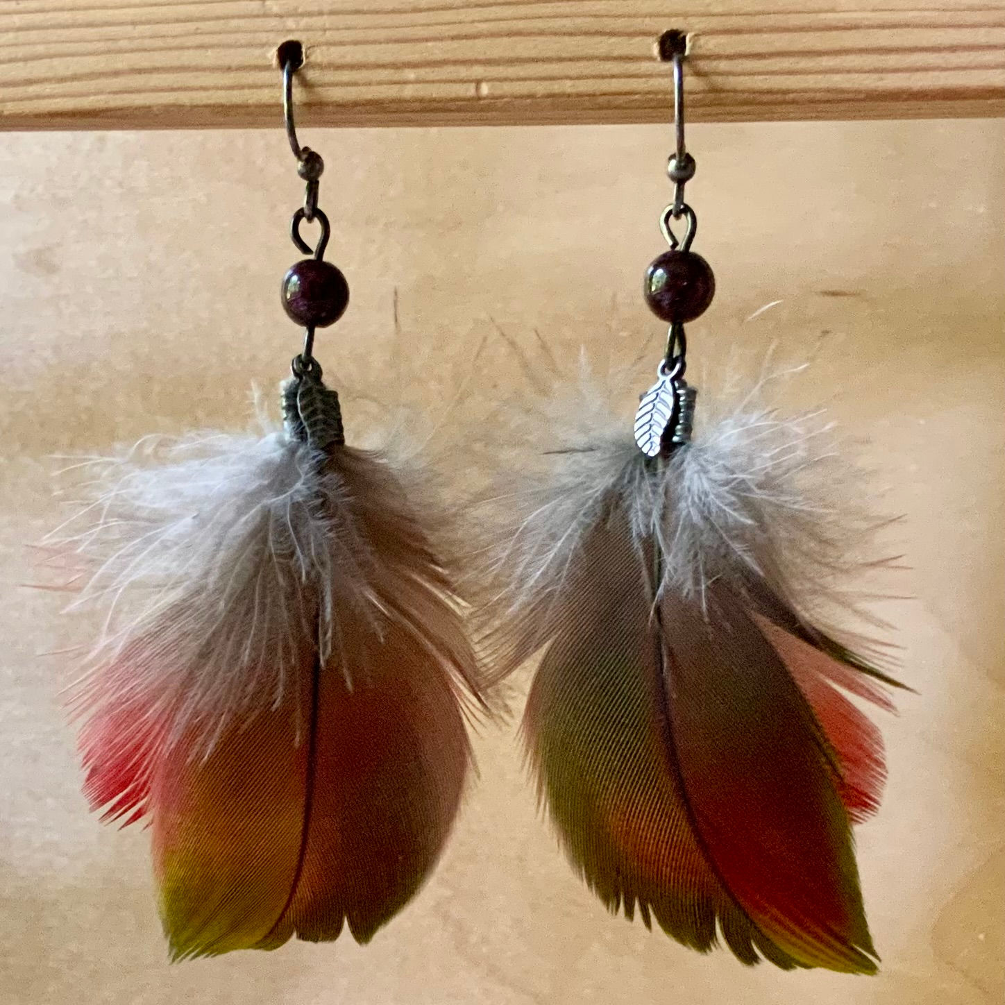 Parrot feather earrings with garnet at metaphysical crystal shop Canada