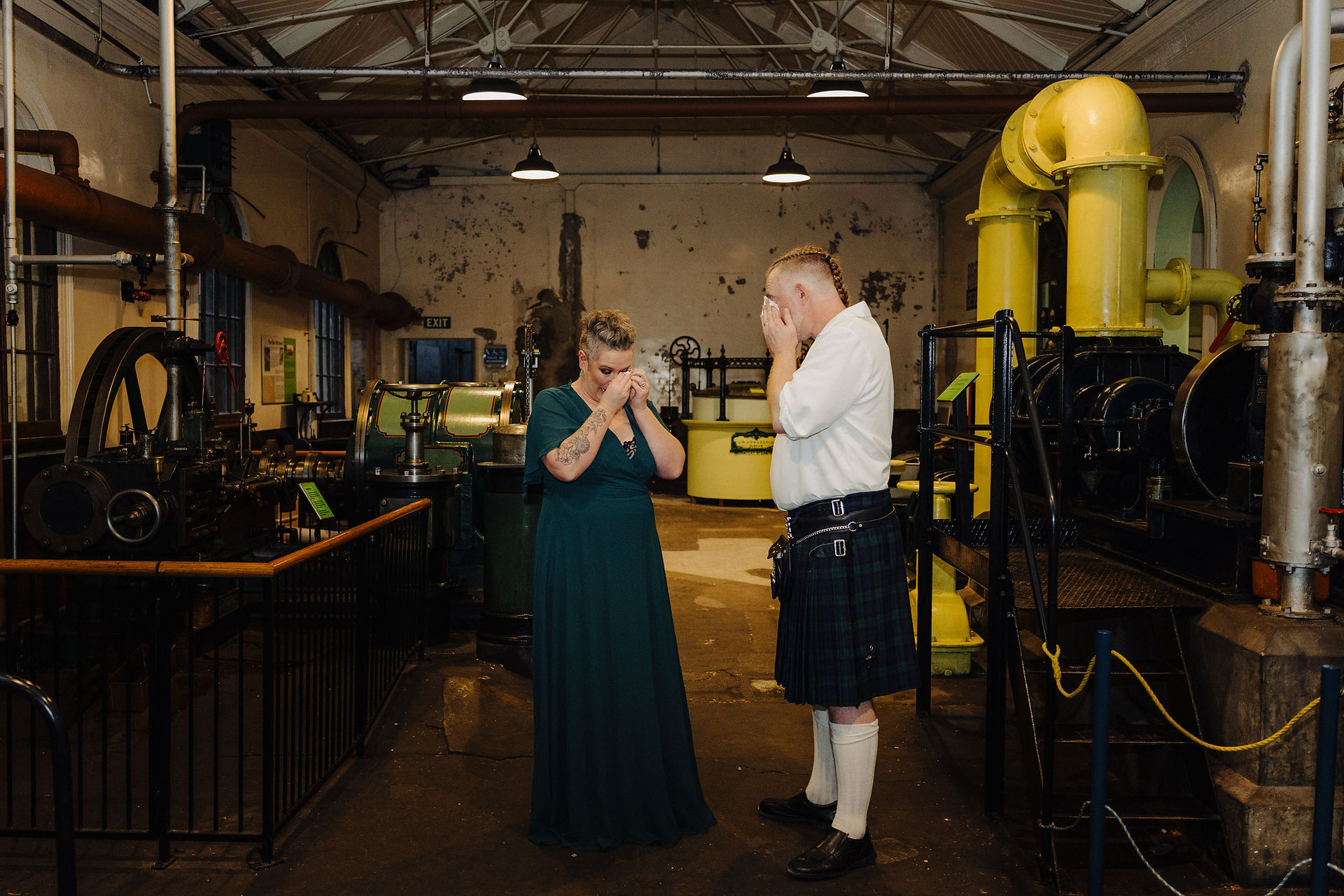 Couple wiping their eyes after emotional vow renewal ceremony in industrial space Dunedin New Zealand