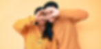 A young dark-haired couple, joining their hands up in the air to make a heart symbol over their eyes