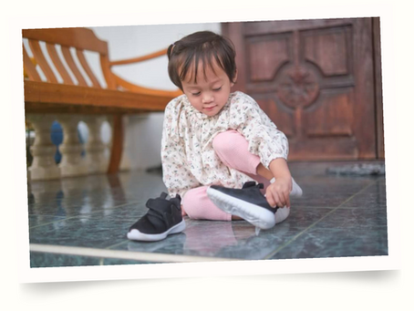 little girl putting on her shoes