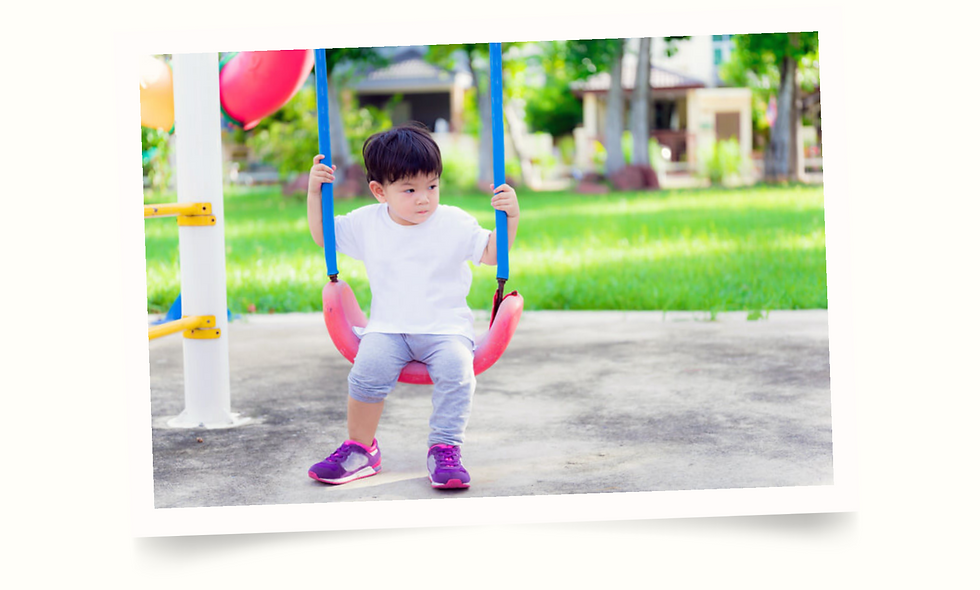 toddler sitting on swing in park