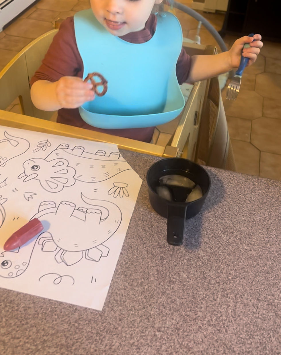 child coloring and eating a pretzel
