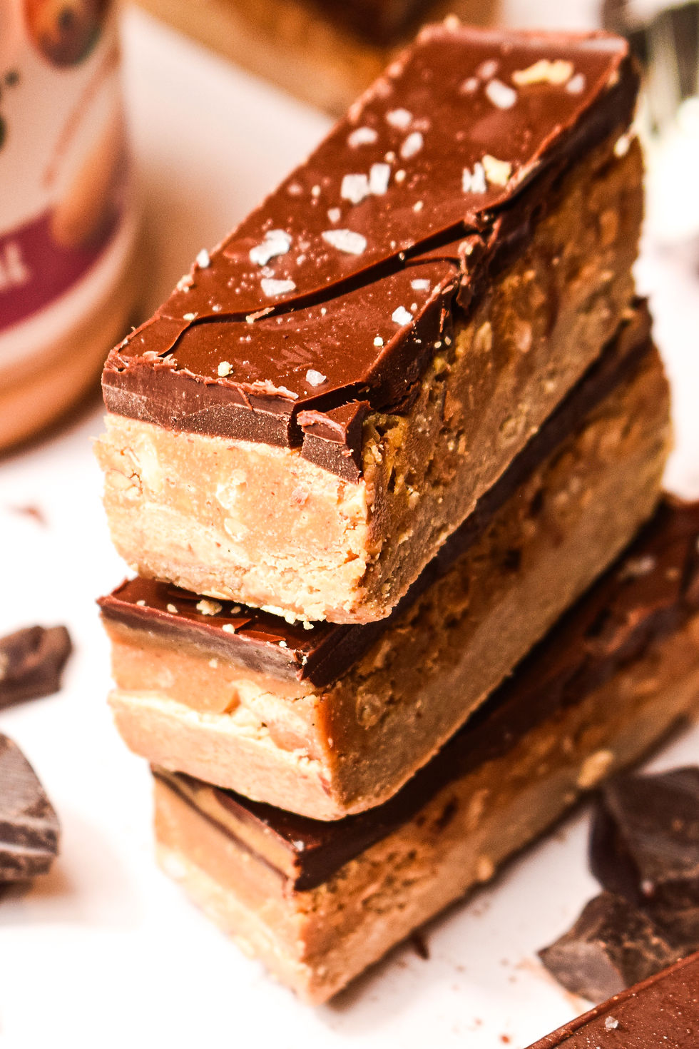 Protein snickers bars with crunchy peanut butter in the background