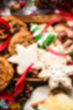 Festive cookies shaped like a snowflake and Christmas trees on a metal cooling rack. Green and white icing, sprinkled with sugar.