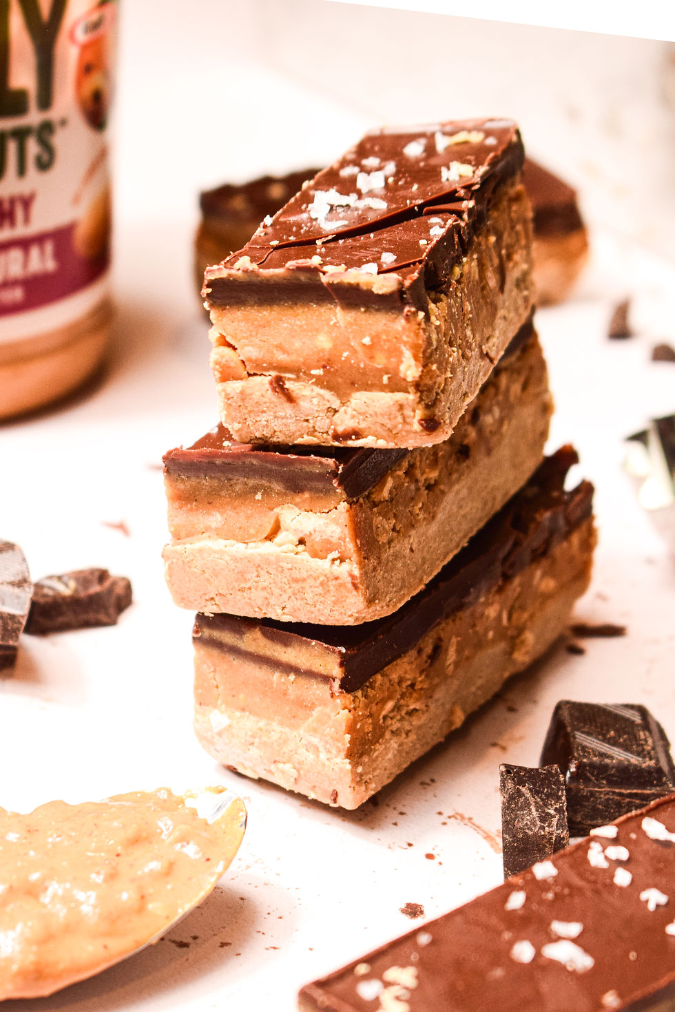 Protein snickers bars with crunchy peanut butter in the background