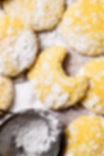 Rustic classic lemon crinkle cookies on a parchment paper background