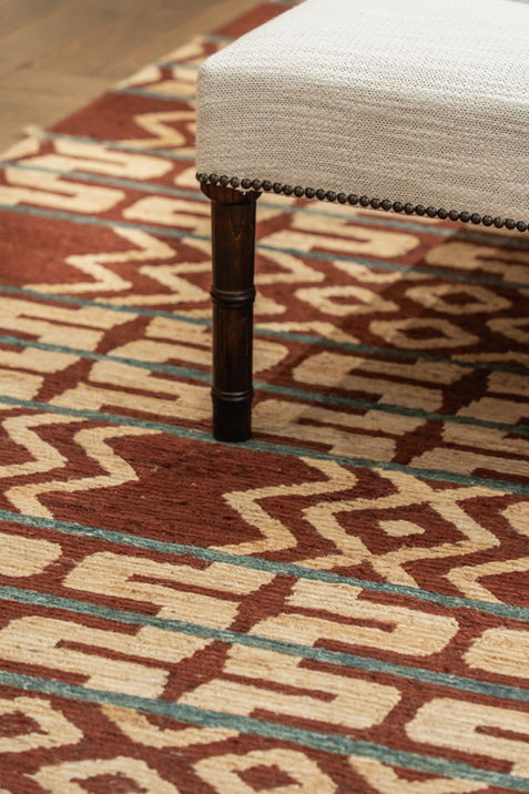 Tim Page Carpets rugs close up detail with cream fabric ottoman sitting on the rug