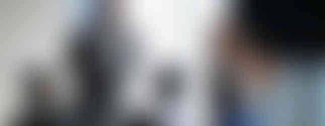 Two adults speaking to a group of young people