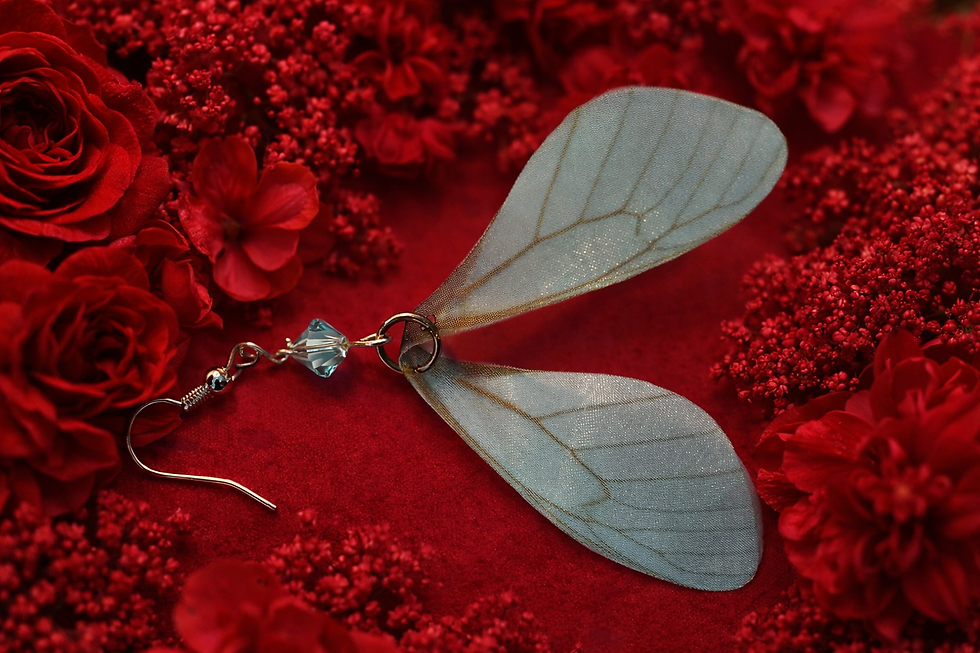 Thumbnail: Turquoise butterfly wing earring with silver hook and pale blue crystal bead on deep red floral background