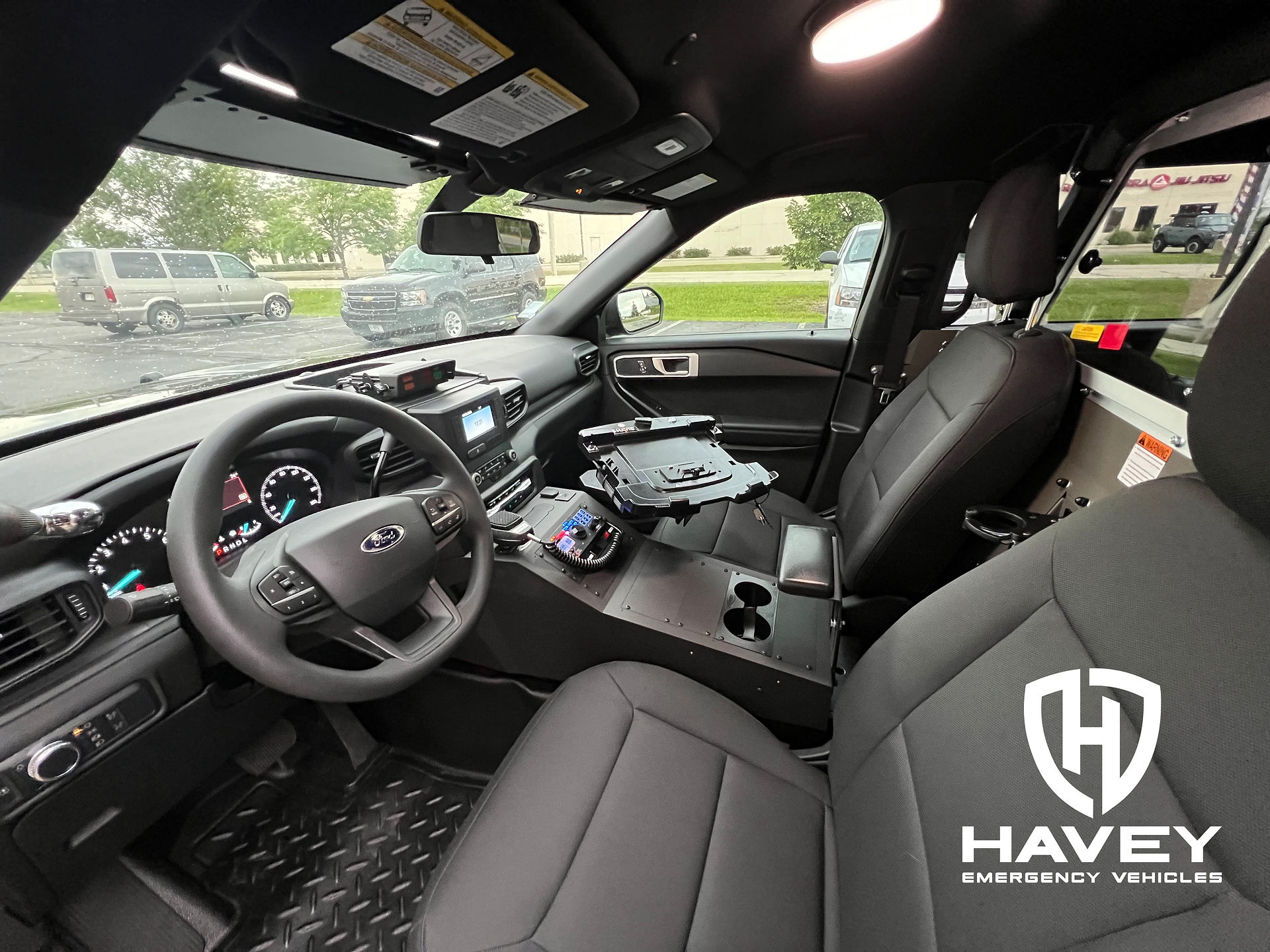 2023 Ford Utility front seat with Jotto Desk contour console, Code 3 XCEL siren and lighting controller, Havis computer tray and Santa Cruz cuff-style gun lock.