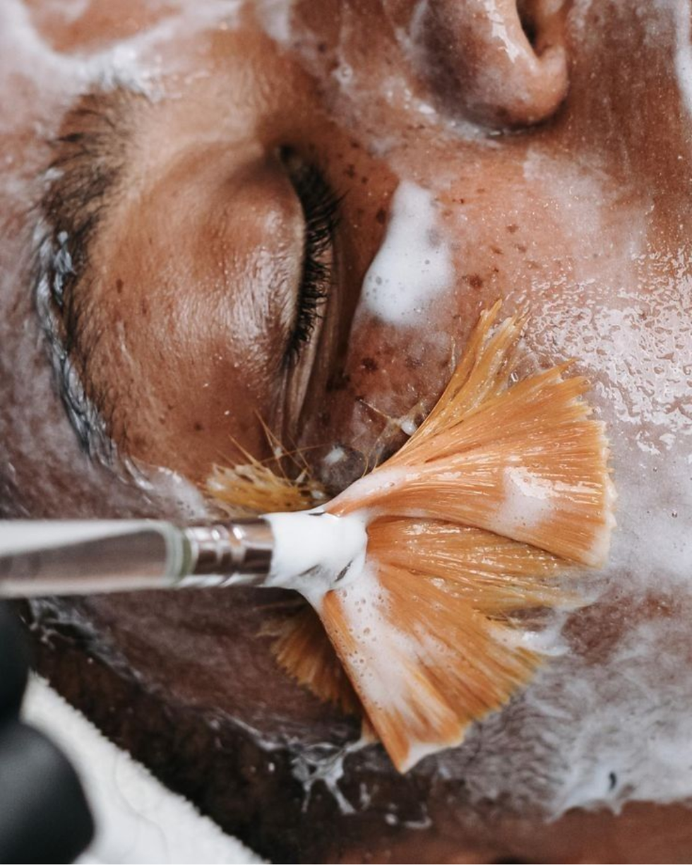 Photo of a brush applying skincare products to the skin
