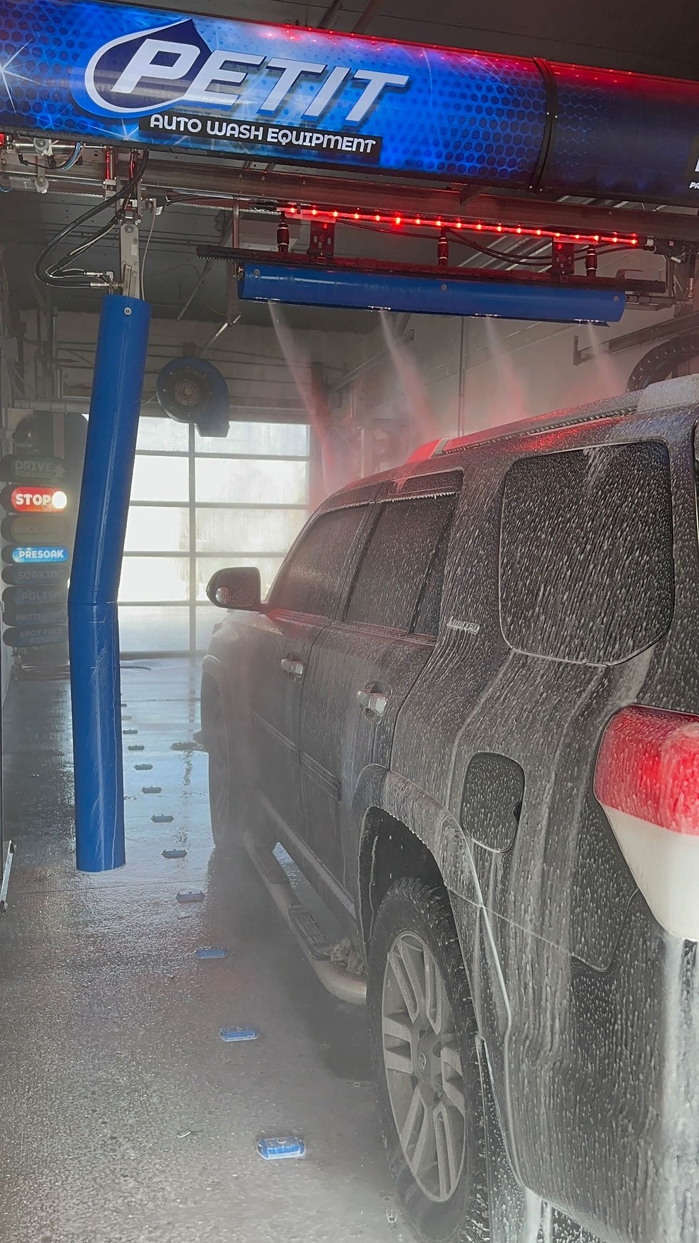 “truck covered in road salt and mud being cleaned undercarriage”
