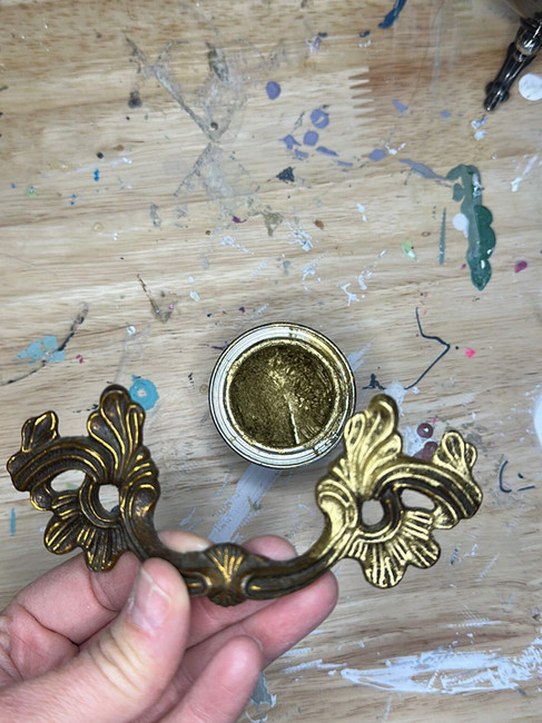 applying gold gilding wax to drawer handle