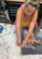 woman in yellow tank top ripping the edges of decoupage paper to make a rough edge for paint blending