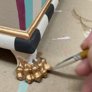 painting gold highlights on feet of whimsical thrifted box