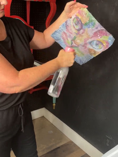 spraying water on back of cat decoupage paper