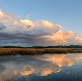 Photograph of glowing clouds above a blue marsh by Peter Cram