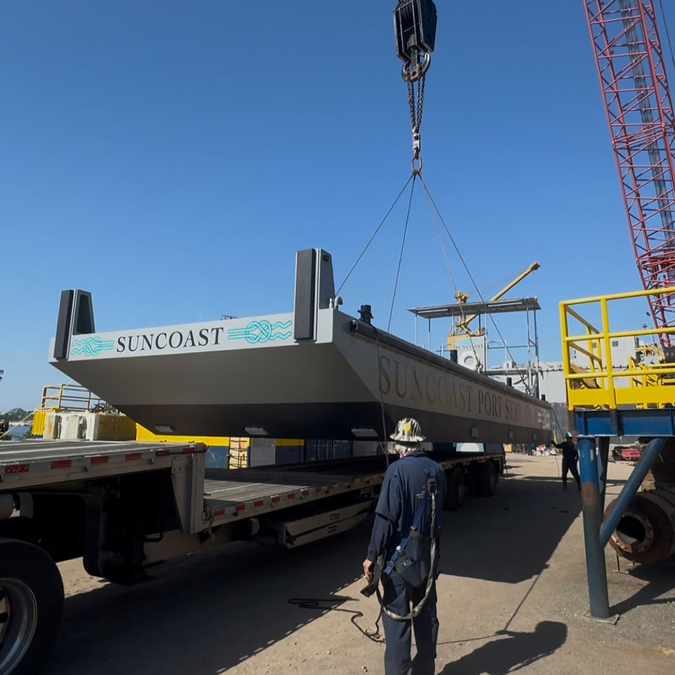 Crane lifting a Suncoast barge by a steel workboat builder.